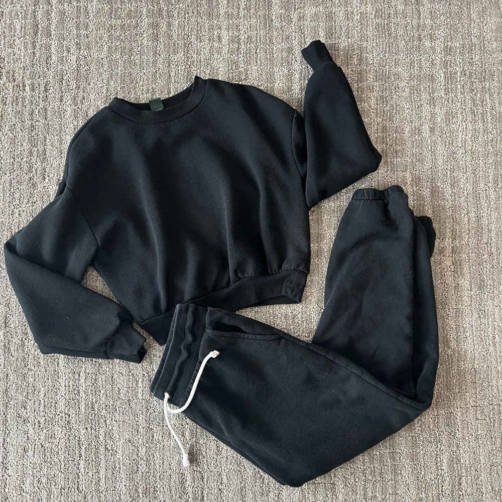 Black sweat suit. the crewneck is cropped and the sweats are high waisted